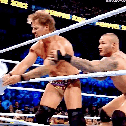 two men are wrestling in a ring and one of them is wearing a thong