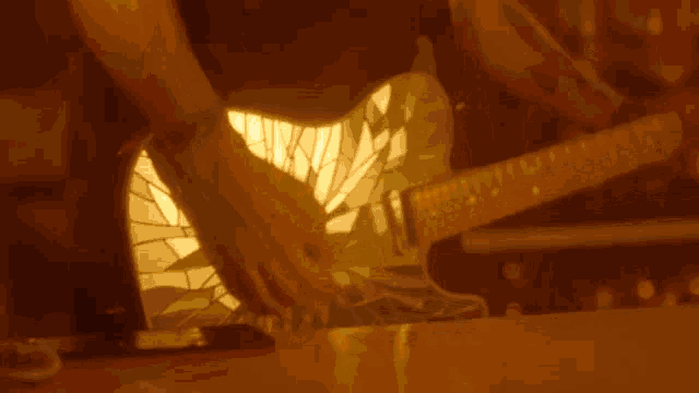 a man is playing a guitar with a broken glass body