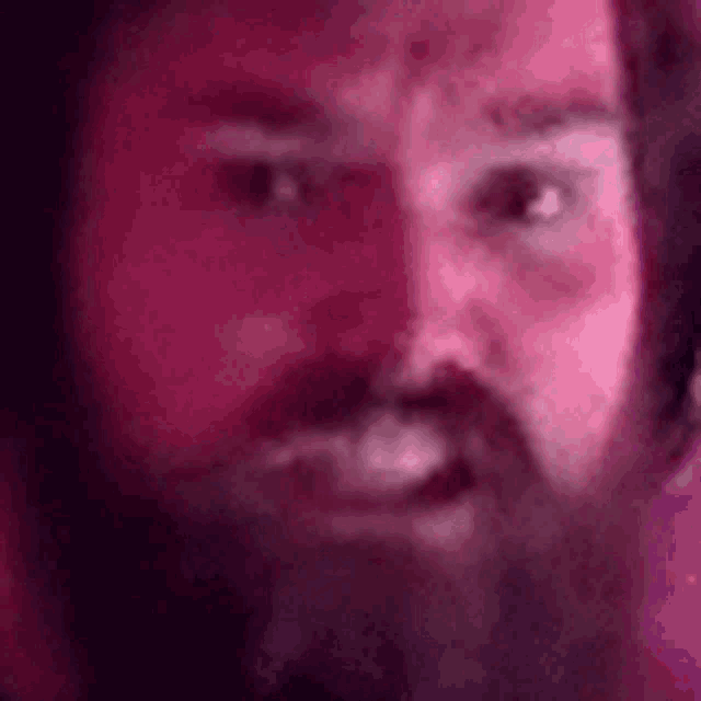 a close up of a man 's face with a beard and headphones on .
