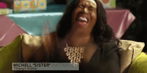 a woman is sitting on a couch and laughing with a name tag that says michelle sister patterson