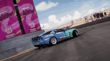 a blue car with falken on the side is driving down a track