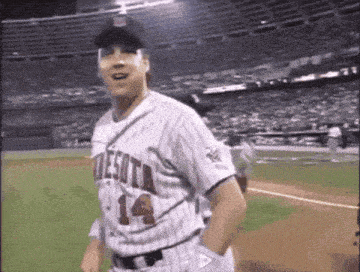 a baseball player wearing a minnesota jersey is standing on the field