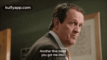 a man in a suit and tie says `` another fine mess you got me into . ''