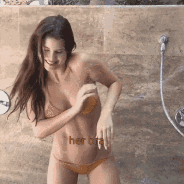 a woman in a bikini is taking a shower and the words her bra are on her stomach