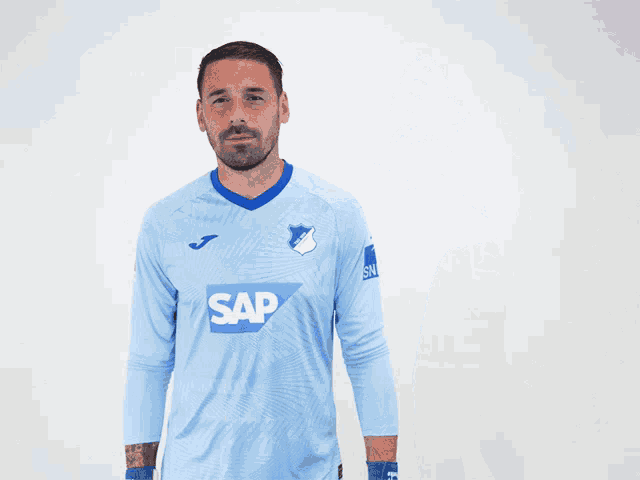 a man wearing a light blue shirt with the number 12 on the back
