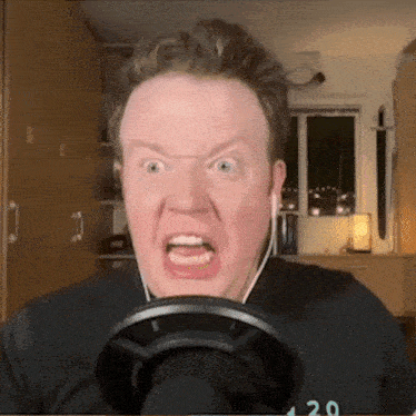 a man wearing a black shirt with the number 20 on it is making a funny face