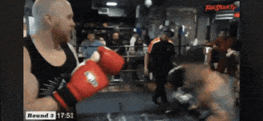 a man wearing red boxing gloves is fighting another man in a boxing ring with the time of round 3 17:51