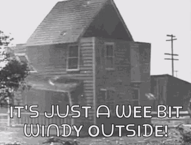 a black and white photo of a house with the words " it 's just a wee bit windy outside "