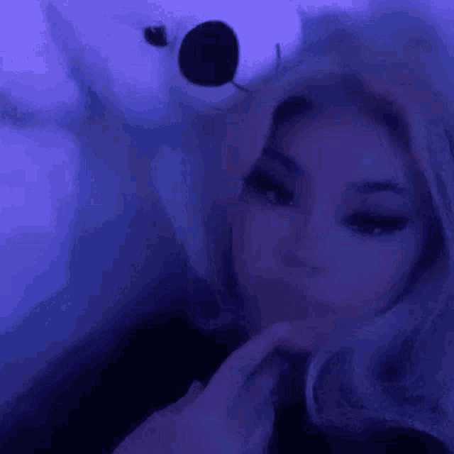 a girl is holding a teddy bear in her hand in a purple room .