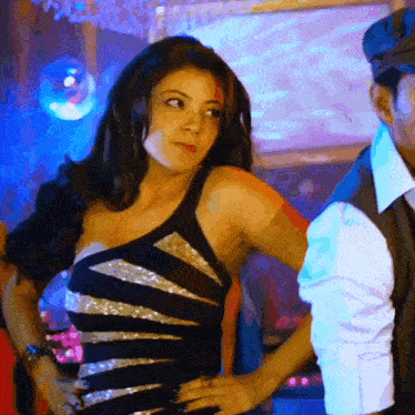 a woman in a black dress stands next to a man
