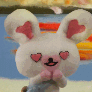 a stuffed bunny with hearts in its eyes is smiling