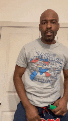 a man is wearing a transformers shirt