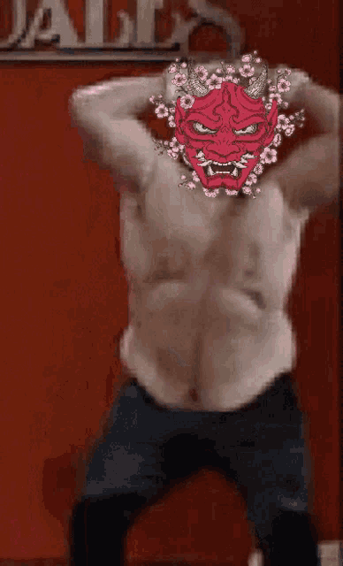 a man without a shirt has a red mask on his face