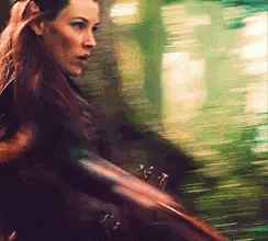 a blurry picture of a woman holding a sword .
