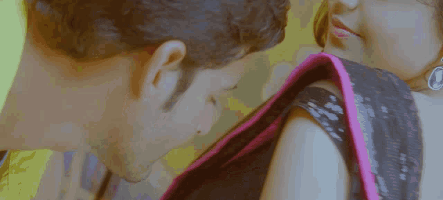 a man kissing a woman 's neck and shoulder