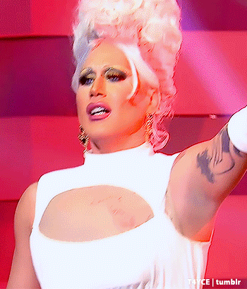 a drag queen with a tattoo on her arm is wearing a white tank top