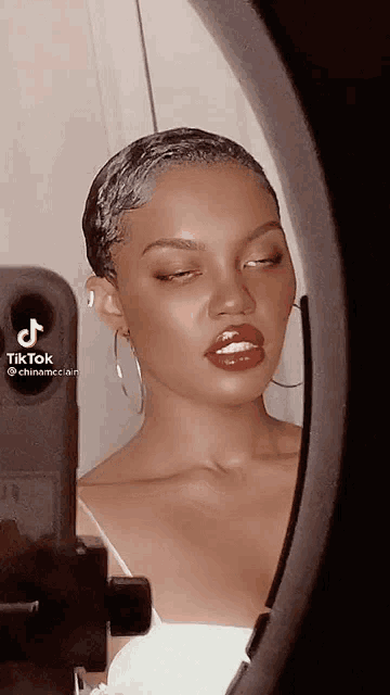 a woman is taking a picture of herself in a mirror with tiktok written on the bottom right corner