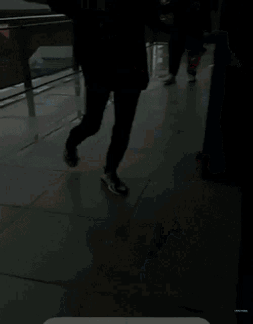 a person wearing a black nrx sweatshirt is running on a tiled floor