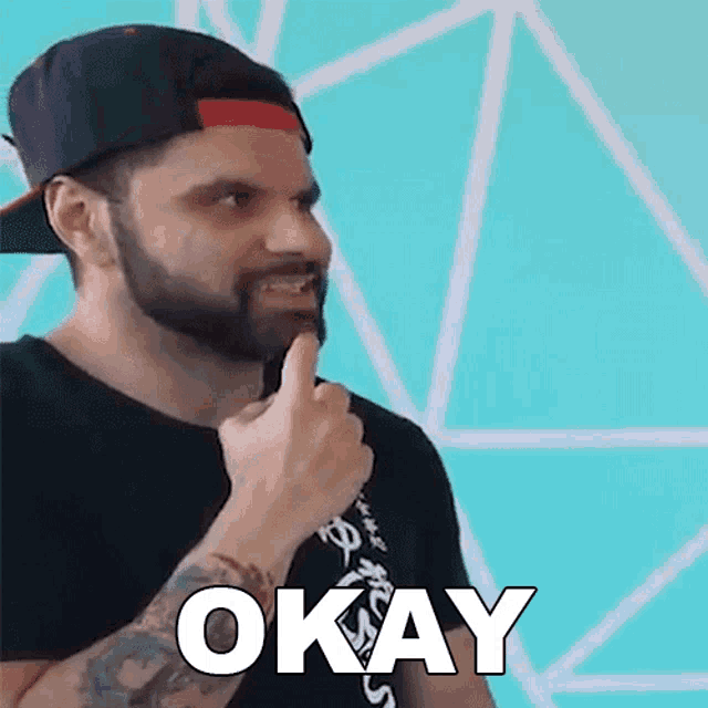 a man with a beard and a hat is giving a thumbs up and the word okay is above him .
