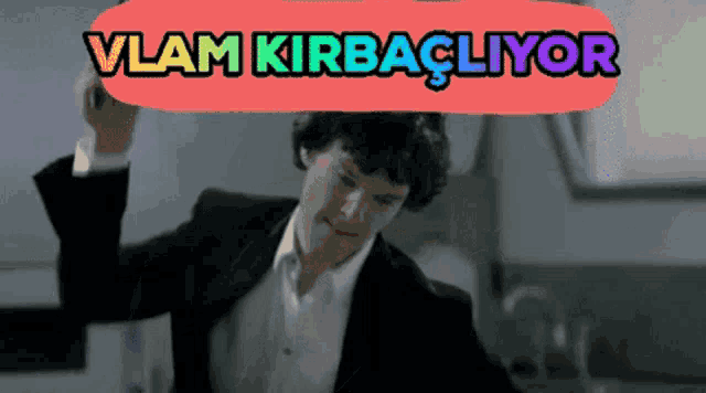 a man in a suit is dancing in front of a sign that says " vlam kirbacliyor "