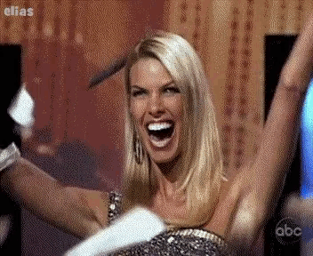 a blonde woman with her arms in the air is on a abc show