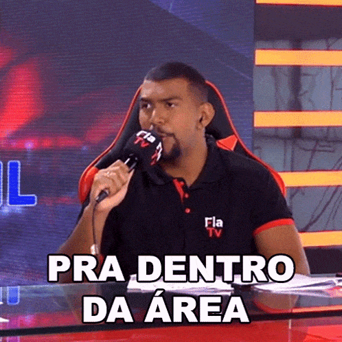 a man sitting at a desk with a microphone and the words pra dentro da area