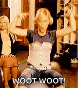 a woman is sitting on a couch with her arms outstretched while another woman sits behind her .