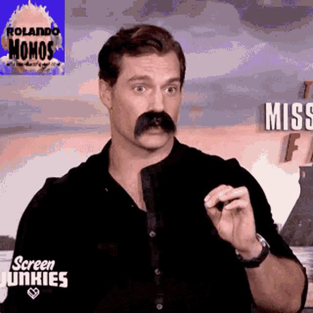 a man with a mustache is wearing a black shirt