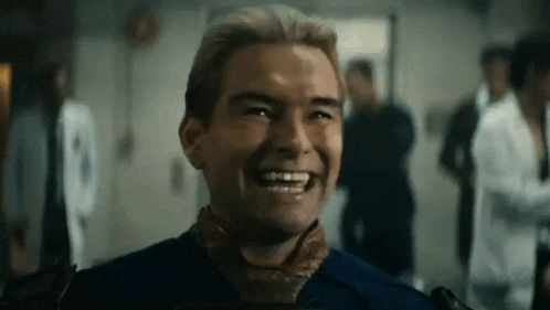 a man is laughing in a room with a group of people .
