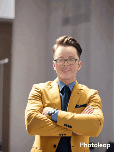 a man in a yellow suit is standing with his arms crossed in front of a sign that says photoleap