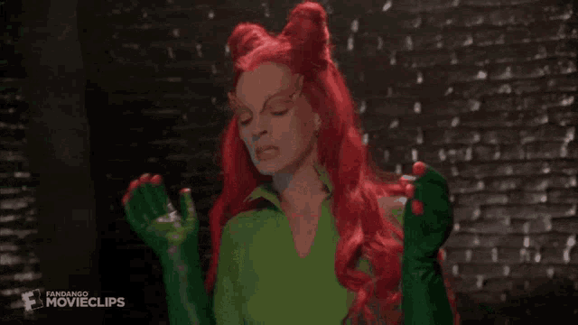 a woman with red hair and green gloves is featured on fandango movie clips