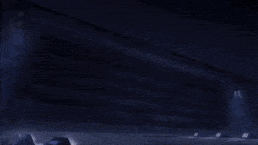 a person is standing in a dark room with a light coming out of the door .