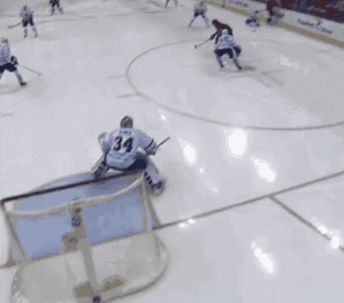 a hockey player with the number 34 on his jersey stands on the ice