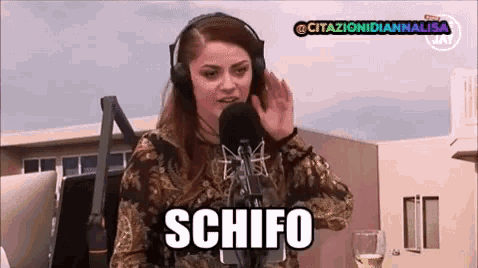 a woman wearing headphones is talking into a microphone and says schifo .