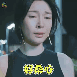 a woman in a black tank top is crying and has chinese writing on her face .