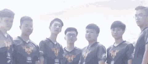 a group of young men standing next to each other in a row .