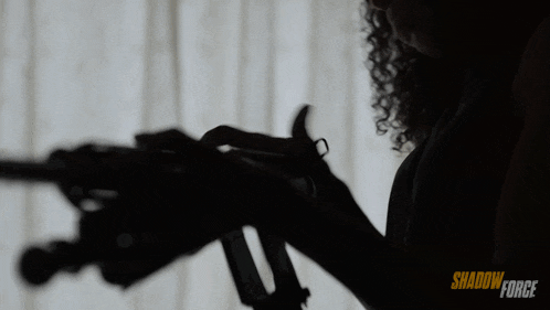 a woman is holding a gun in front of a window with shadow force written on the bottom