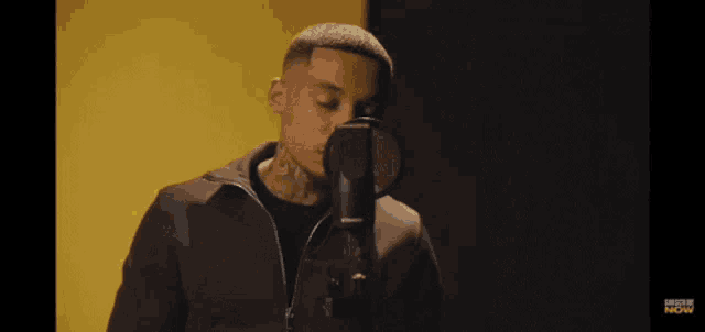 a man singing into a microphone with the word fear written in yellow