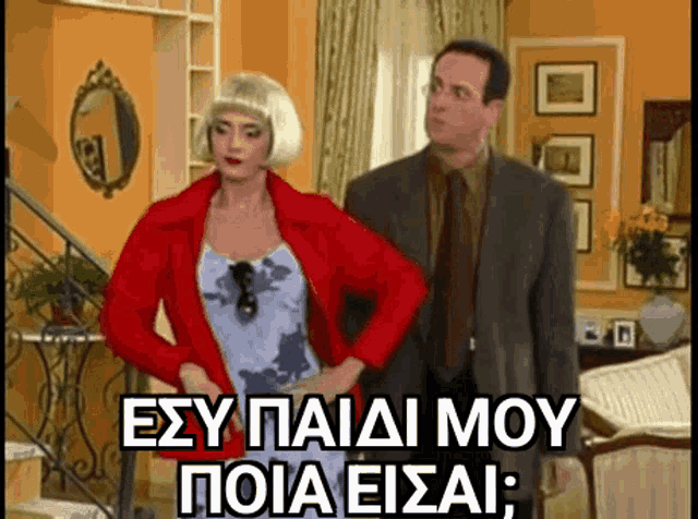 a man and a woman are standing next to each other in a living room and the woman is wearing a wig .
