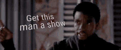 a man is standing in front of a window with a sign that says get this man a show .