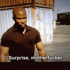 a man in a brown shirt says surprise motherfucker in a parking lot