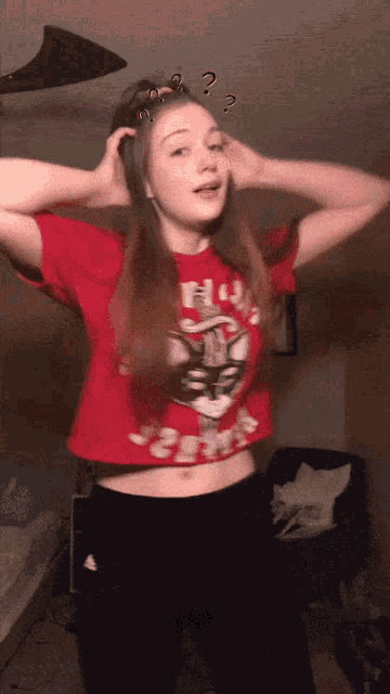 a girl wearing a red crop top with a picture of a man on it
