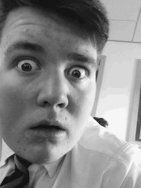 a man in a white shirt and tie is making a funny face
