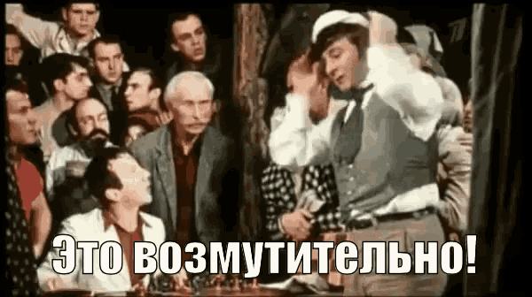 a group of men are standing around a table with a man standing in the middle of the room .