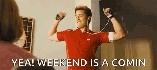 a man in a red shirt is flexing his muscles while wearing headphones and a watch .