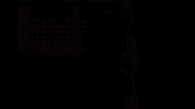 a silhouette of a person standing in front of a yellow wall