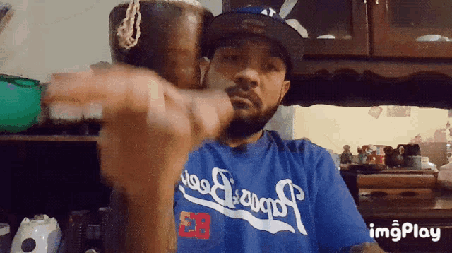 a man wearing a blue dodgers shirt is holding something in his hand