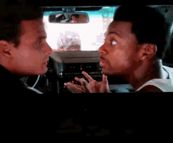 two men are having a conversation in a car with a rear view mirror in the background