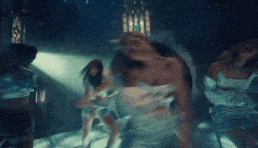 a group of people are dancing in a dark room in front of a church