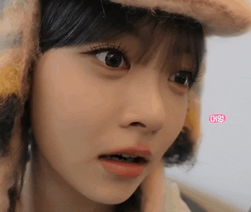 a close up of a woman wearing a hat with a pink sticker that says ' ae ' on it